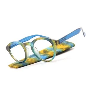 Augenstolz Fertiglesebrille Cloudy Blue – runde Lesebrille mit blau-gelbem Konfettimuster, schräg auf passendem gemustertem Etui liegend