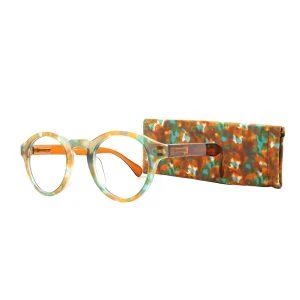 Augenstolz Fertiglesebrille Cloudy Brown – runde Lesebrille mit türkis-orangem Konfettimuster, daneben aufgestelltes passendes gemustertes Etui