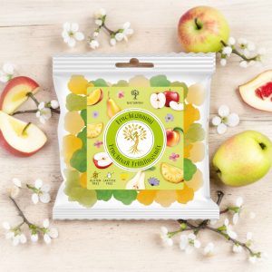 NATURFEH Fruchtgummi auf Joghurtschaum mit Blüten und Früchten im Hintergrund